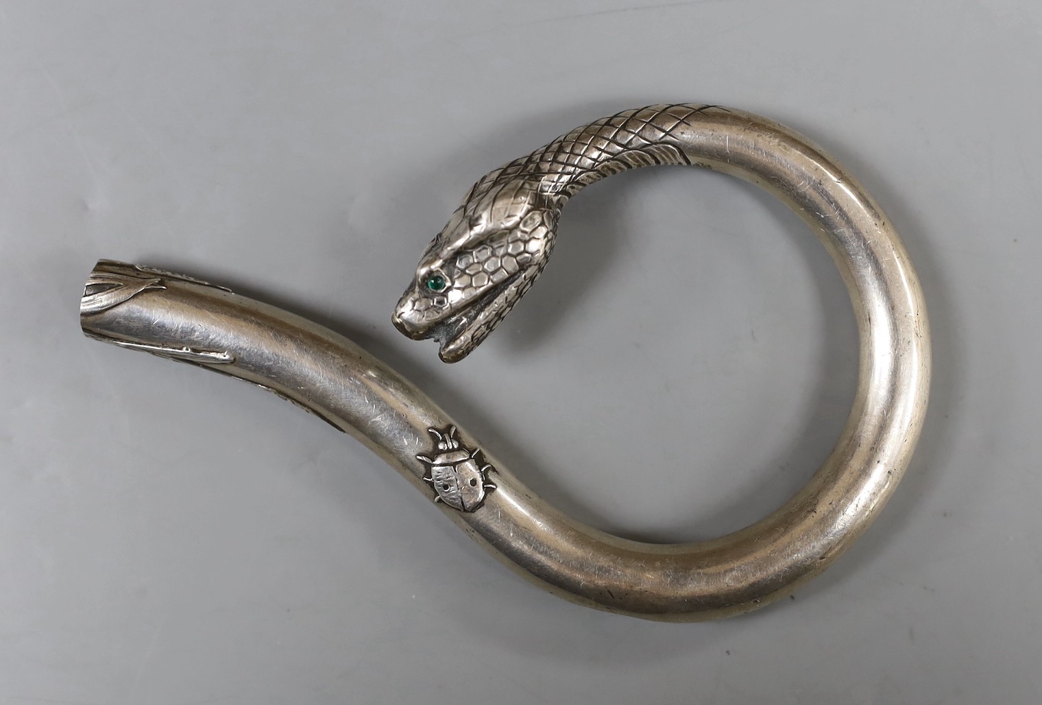 A Japanese? white metal cane handle, with cabochon eyes and terminal modelled as the head of a serpent, 12.2cm, gross weight 55 grams.